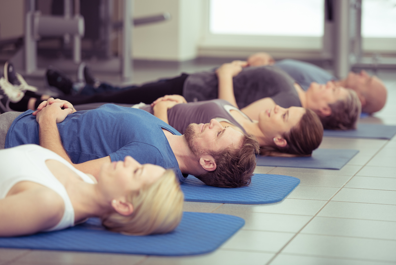 männer und frauen praktizieren entspannungsübungen